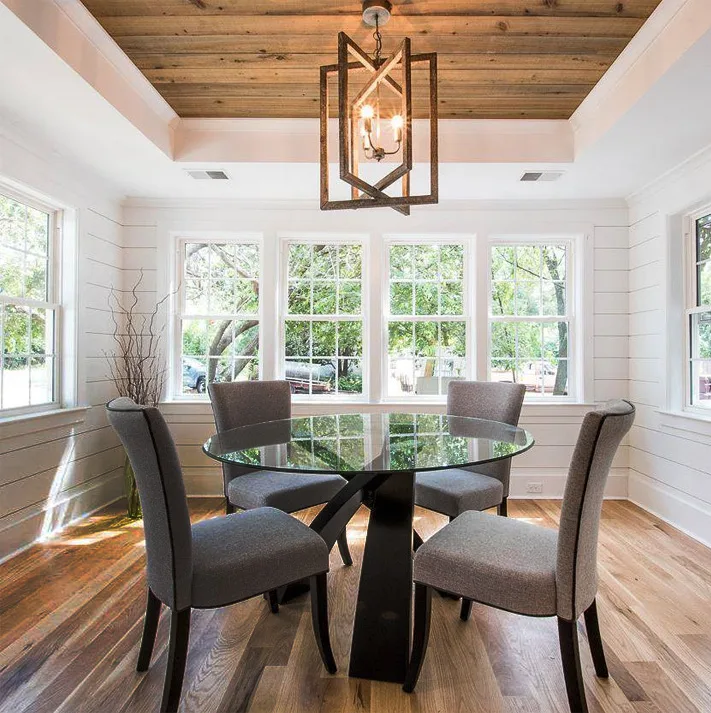 White dining room with wood floors and table.